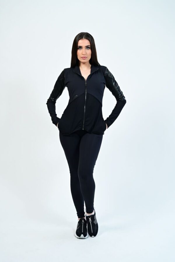 Woman in black athletic wear, standing confidently.