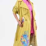 Woman in yellow painted trench coat.