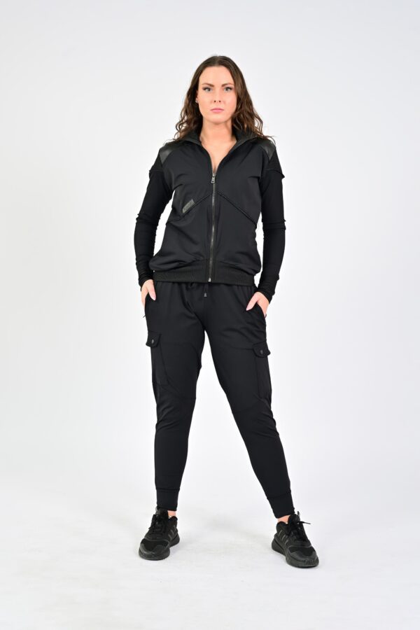 Woman in black athletic outfit posing confidently.