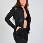 Woman in black sportswear, standing confidently.