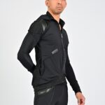 Man in black athletic jacket posing confidently.