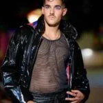 Man in shiny jacket on runway.
