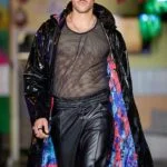 Model in mesh top and shiny coat.