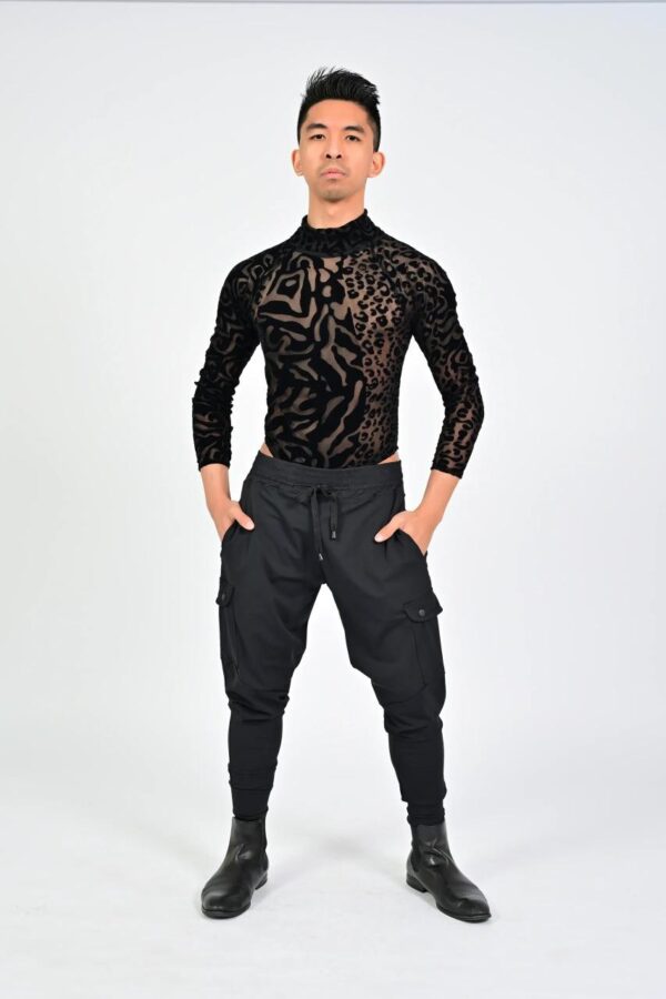 Man in black leopard-print top posing.
