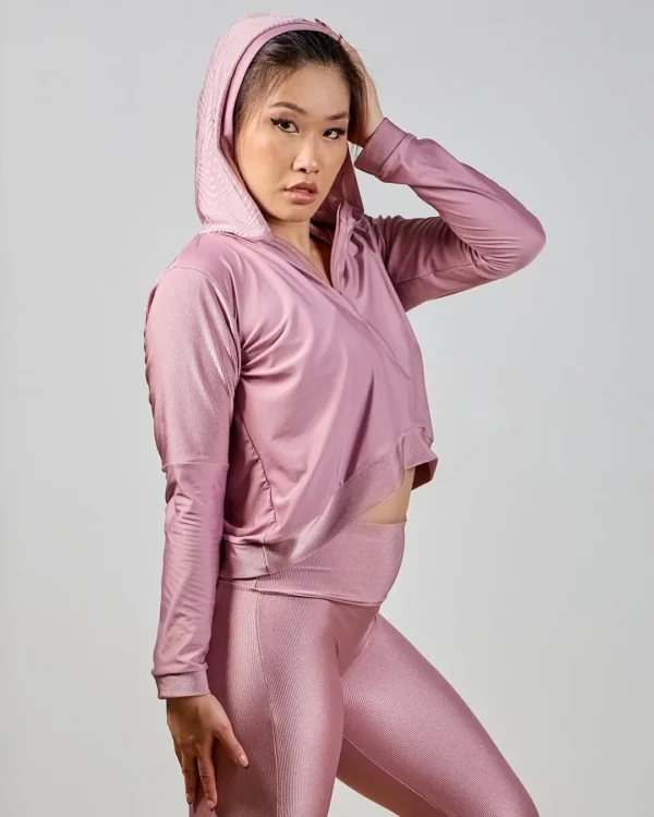 Woman in pink activewear posing confidently.