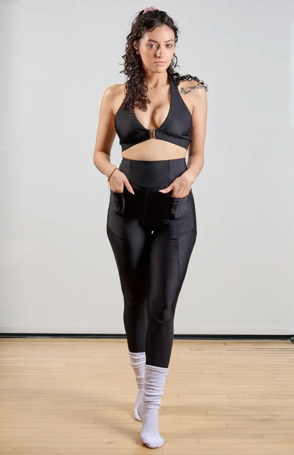 Woman in black athletic wear posing indoors.